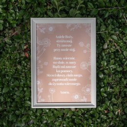 Plakat ze słowami modlitwy do Anioła Stróża otoczonymi białymi kwiatami. Oprawiony w białą frezowaną ramę.