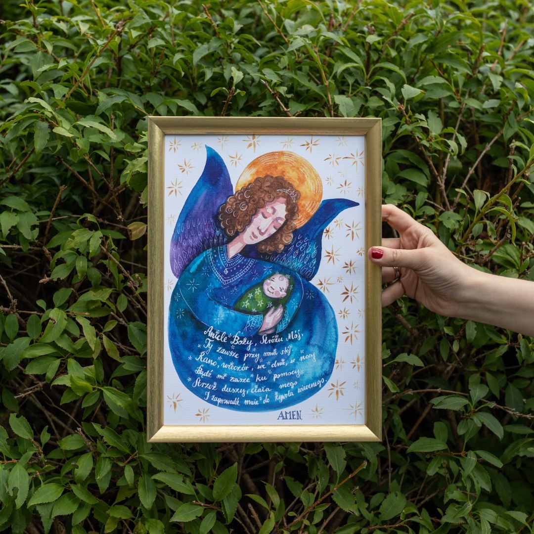 Plakat z ciemnoniebieskim aniołem przytulającym dziecko i modlitwą do Anioła Stróża. Oprawiony w złotą ramę.