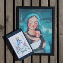 Plakat z Maryją przutulającą małego Jezusa. Oprawiony jest w czarną ramę.