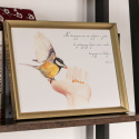 Plakat z ptakiem siedzącym na ręce. Obok kaligrafowany cytat z Pisma Świętego. Oprawiony w złotą ramę.